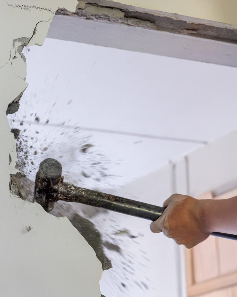 Close-up of a sledgehammer breaking through an interior wall, showing Alcord Construction’s clean, controlled demolition work during home remodeling projects in Middle Georgia.