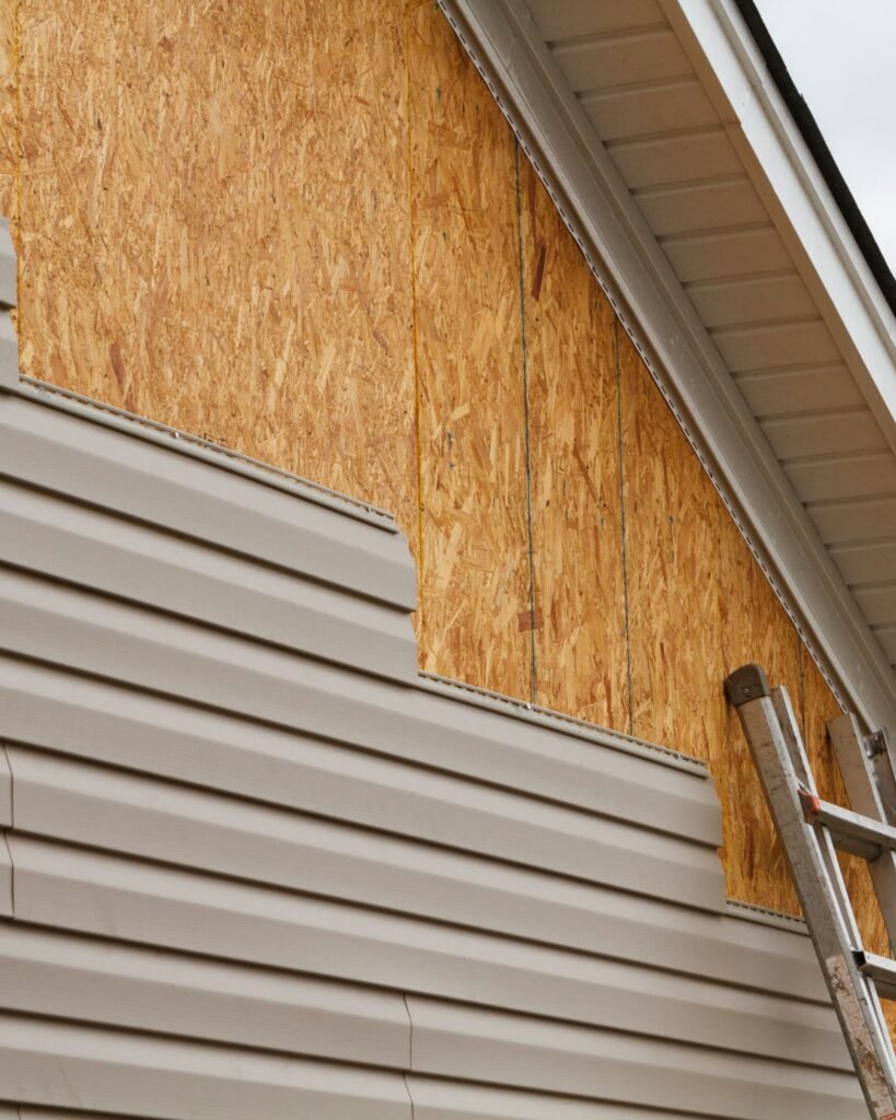 Exterior wall showing new OSB sheathing and partially removed vinyl siding, highlighting Alcord Construction’s precise siding repair and replacement work in Middle Georgia.