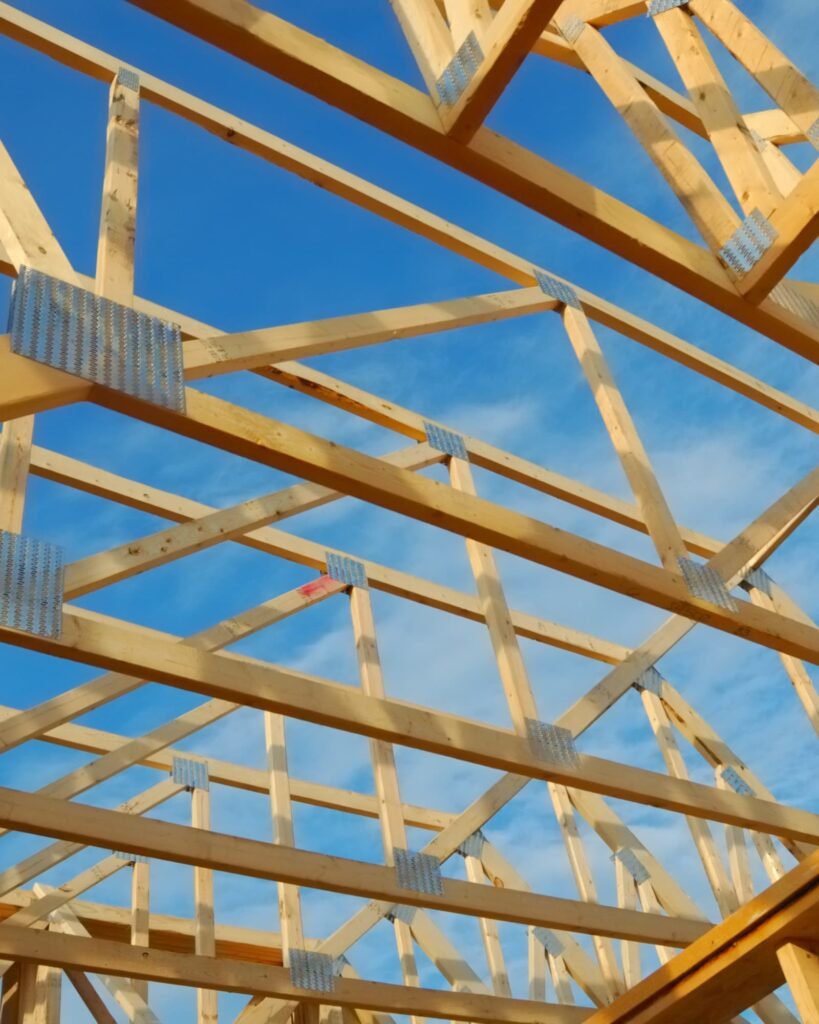 Wooden roof trusses and framing set against a blue sky, showcasing Alcord Construction’s strong structural building work and precise craftsmanship in Middle Georgia.